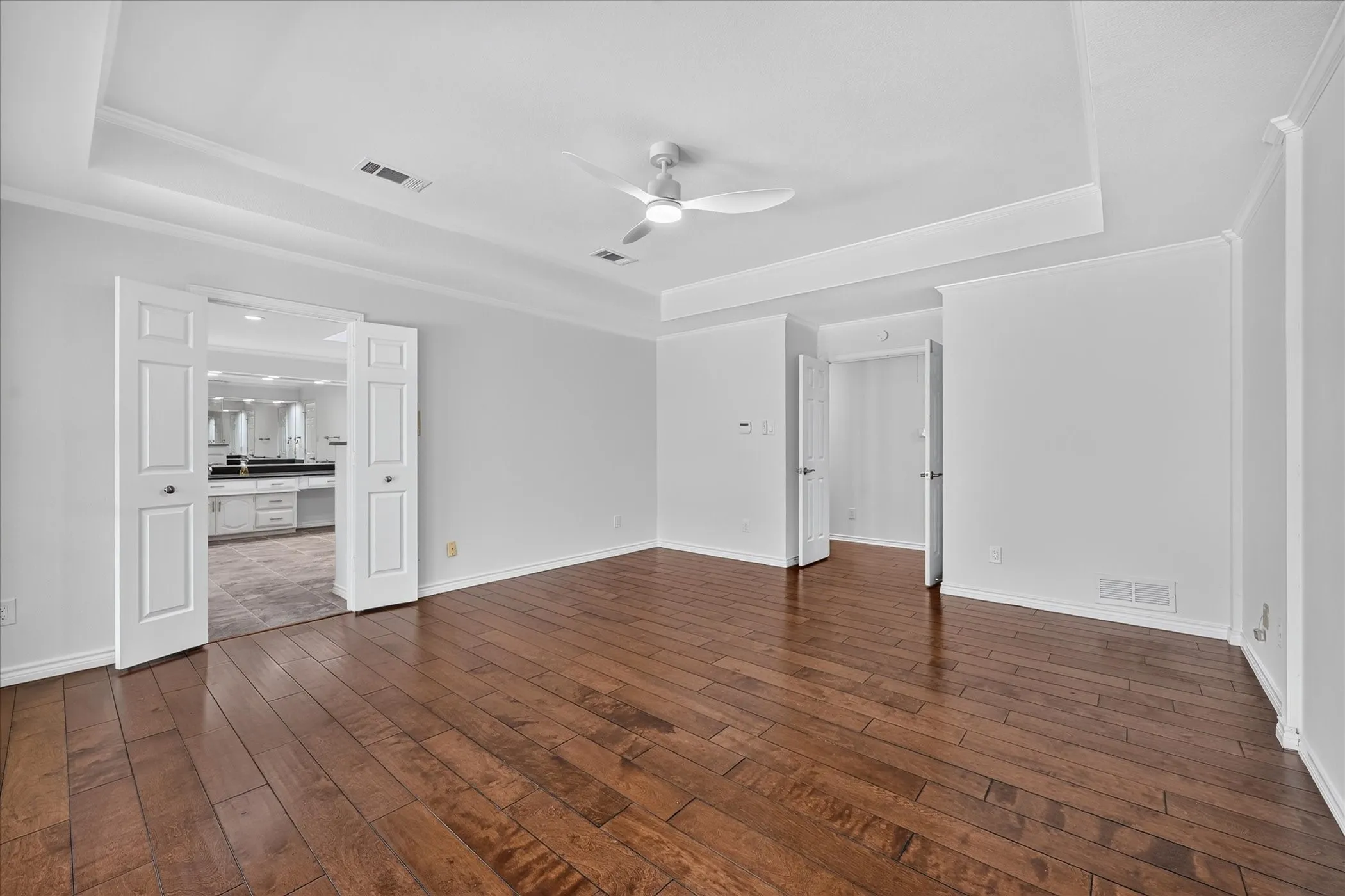 wood-finish flooring, large primary, panned ceiling