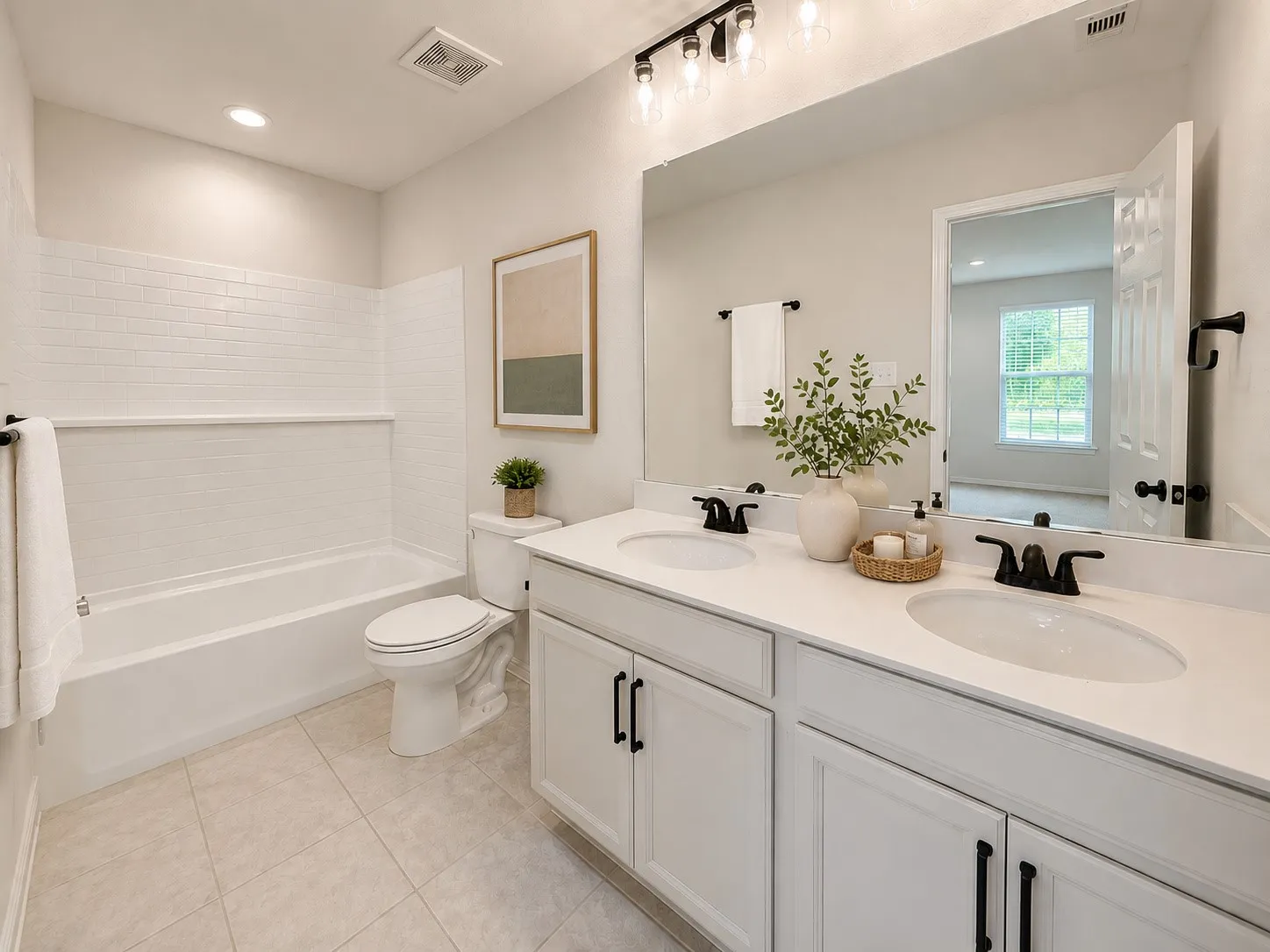 Double vanity with white cabinetry, matte black hardware, and an expansive mirror
