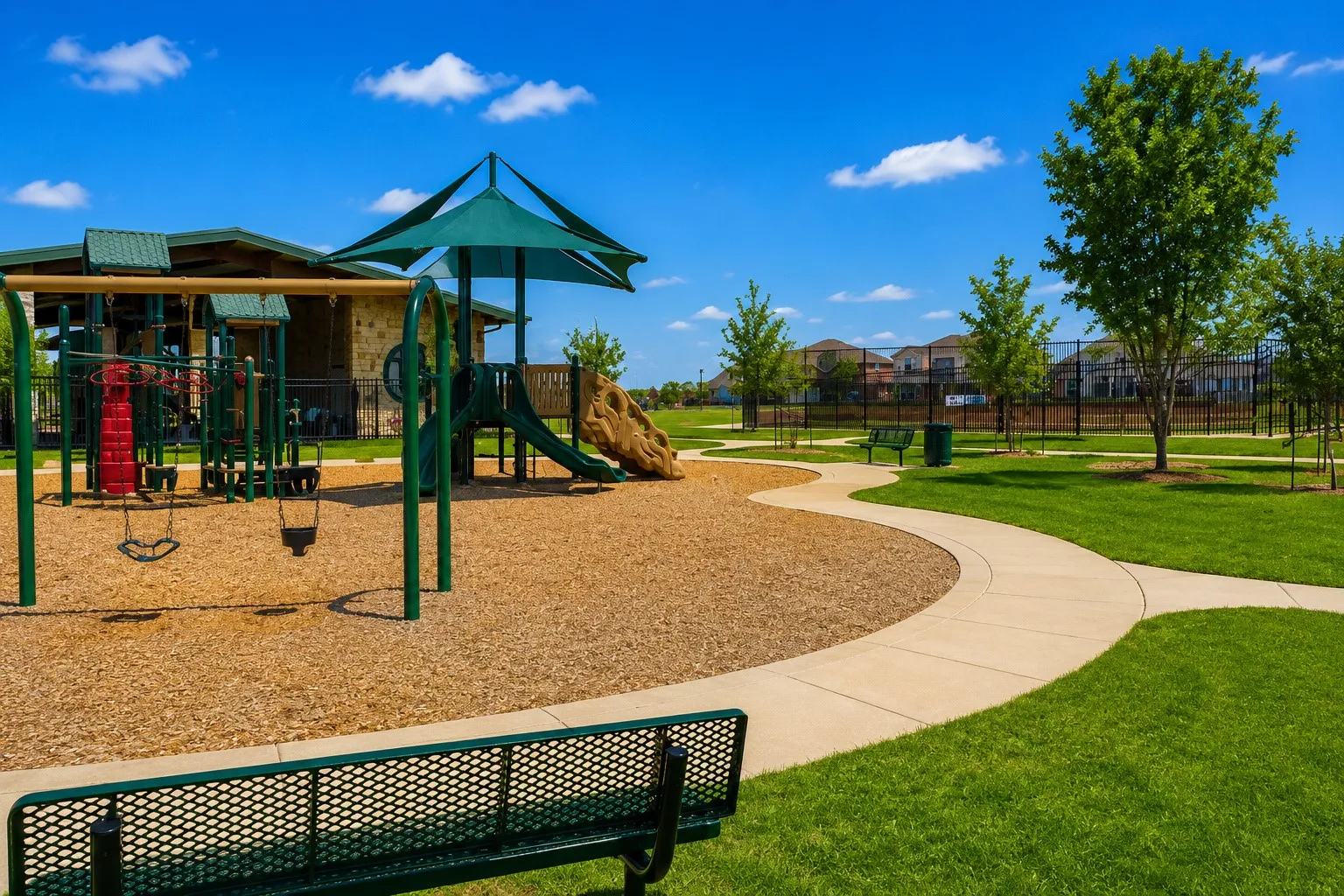 Playground with swings, slides, shade canopy, and a nearby stone-clad structure