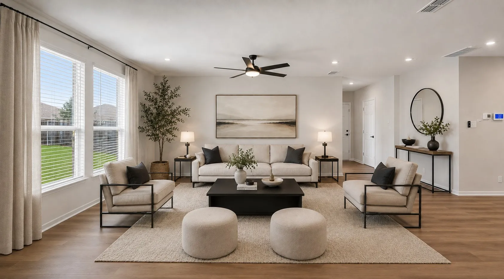 Recessed lighting illuminates the open living space, featuring wood-finish flooring and multiple windows