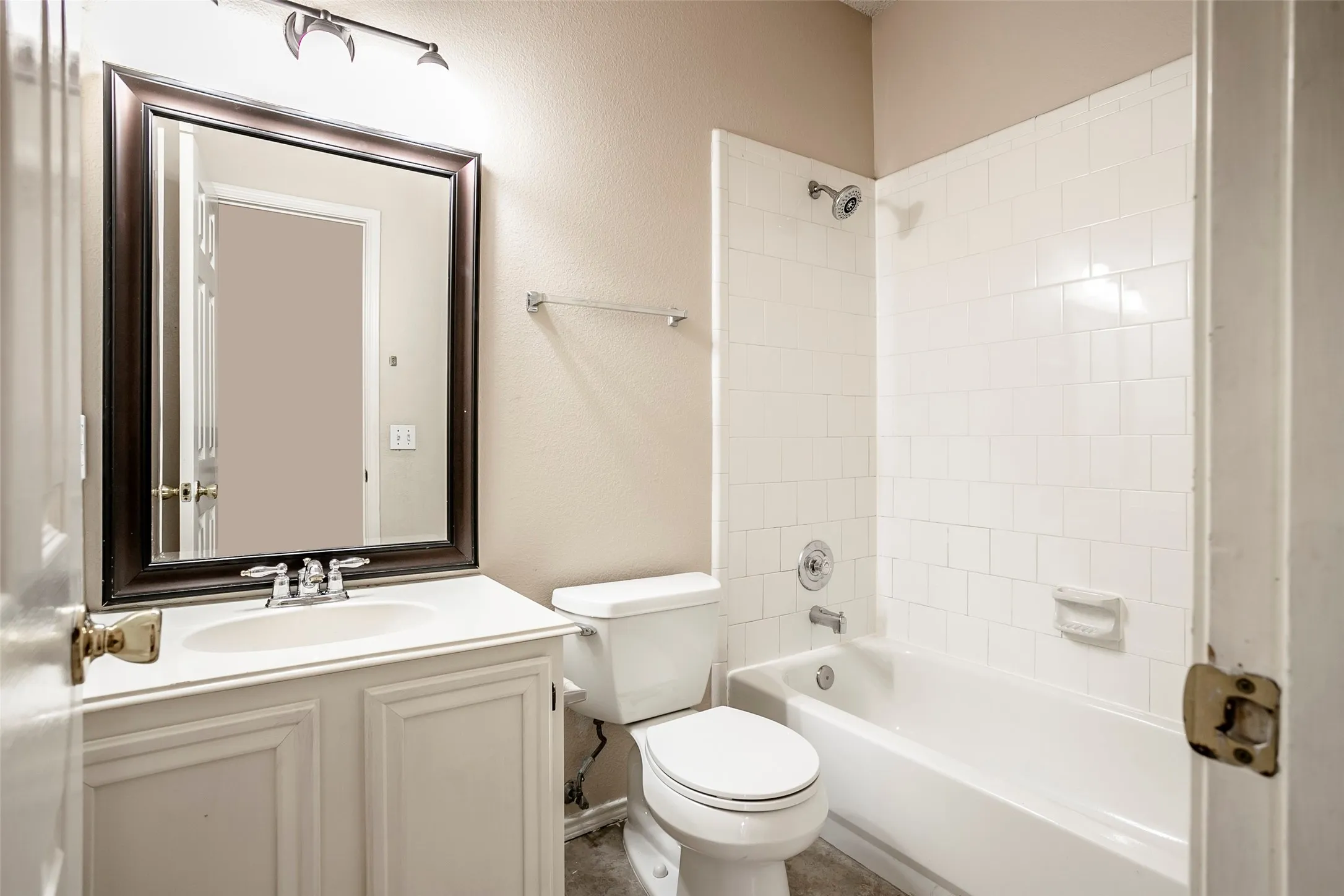 Bathroom featuring a white vanity with an integrated sink, framed mirror, and track lighting