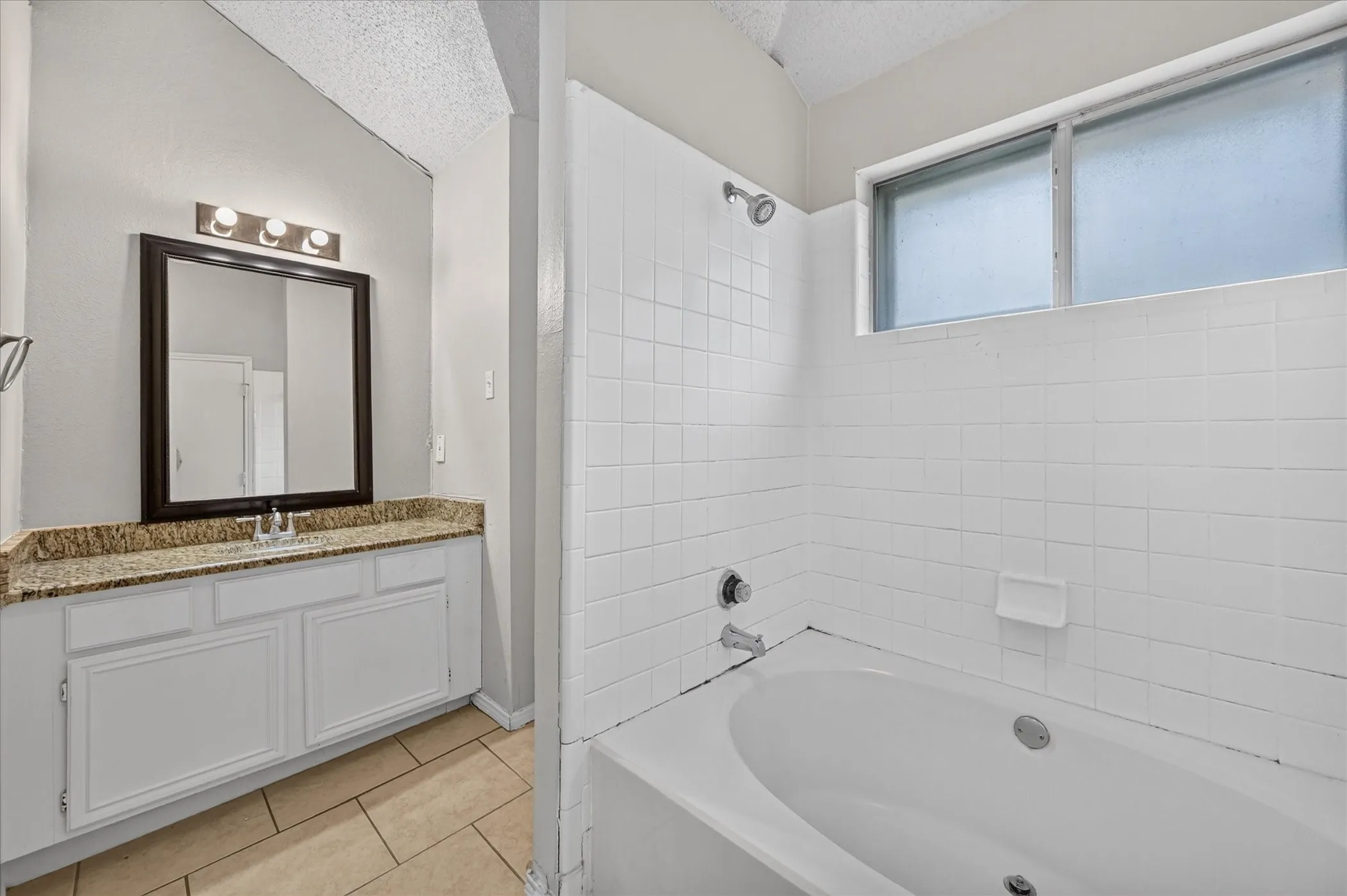 Vanity with a polished stone countertop and integrated sink