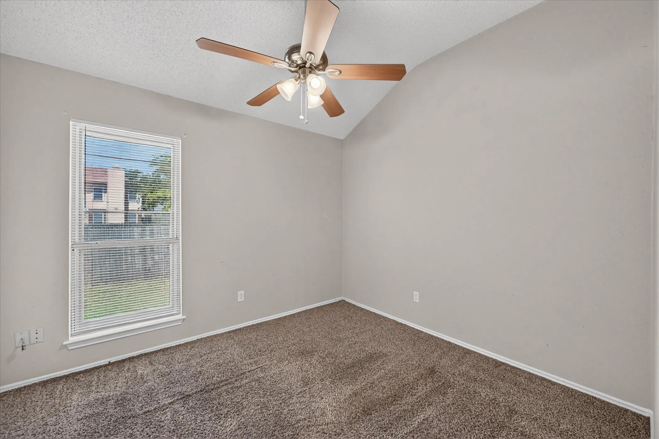 Vaulted ceiling with a ceiling fan, neutral wall paint, window with blinds, and carpet flooring