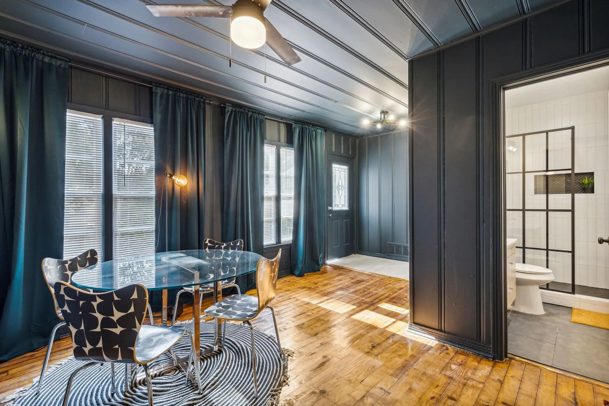 Hardwood flooring throughout, with a ceiling fan light fixture, and track lighting