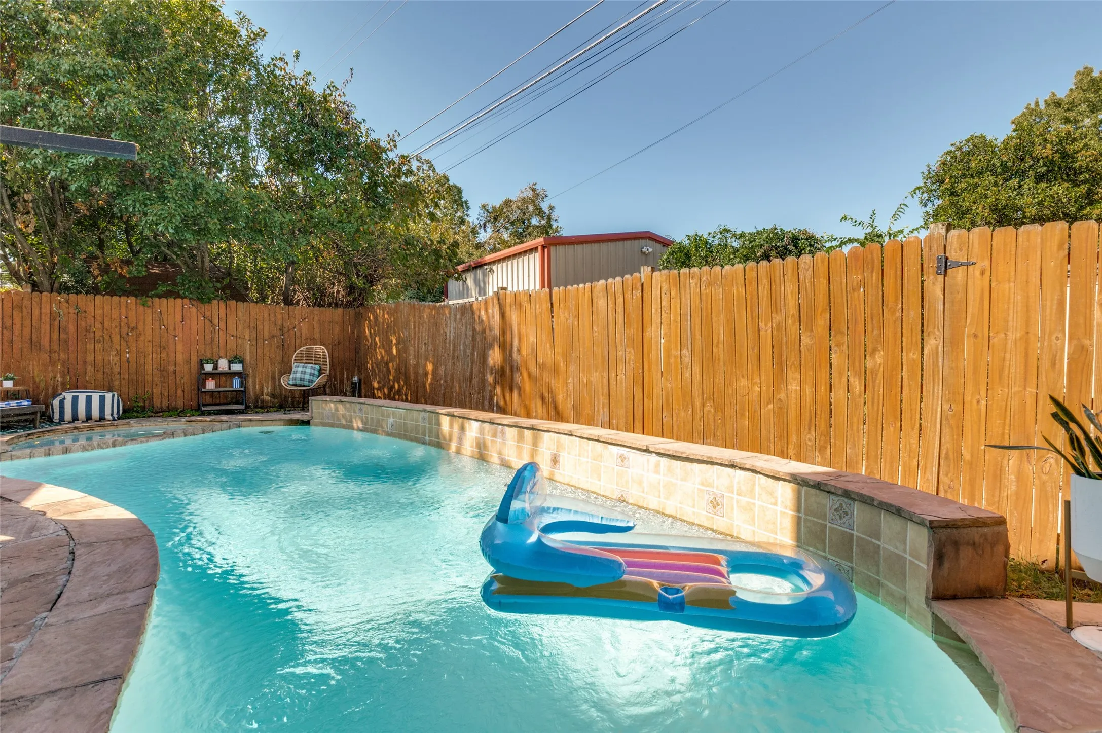 In-ground swimming pool with a stone coping and a tiled perimeter wall