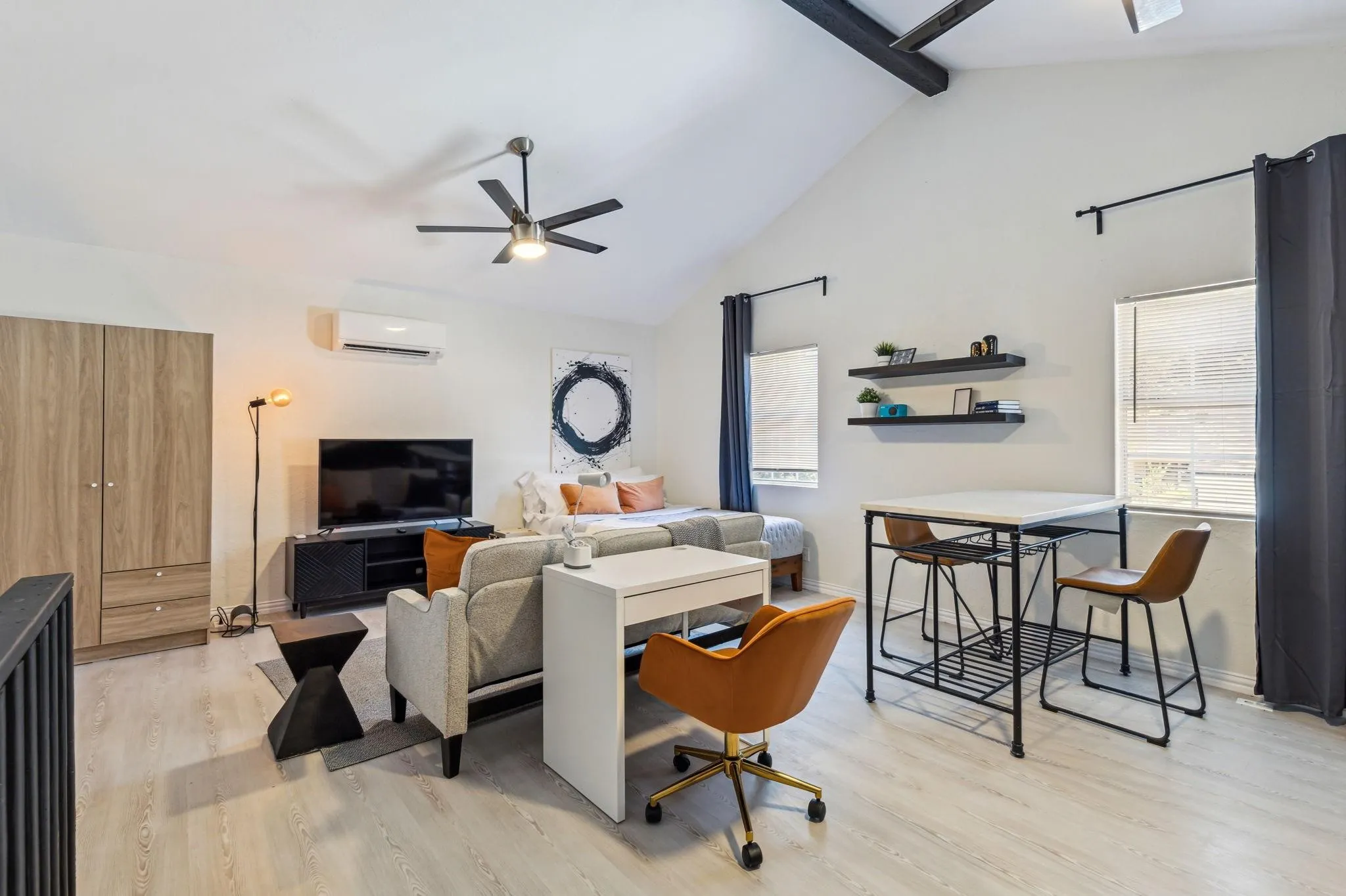 Vaulted ceilings, wood-finish flooring, ceiling fan, built-in wardrobe, and mini-split air conditioning unit