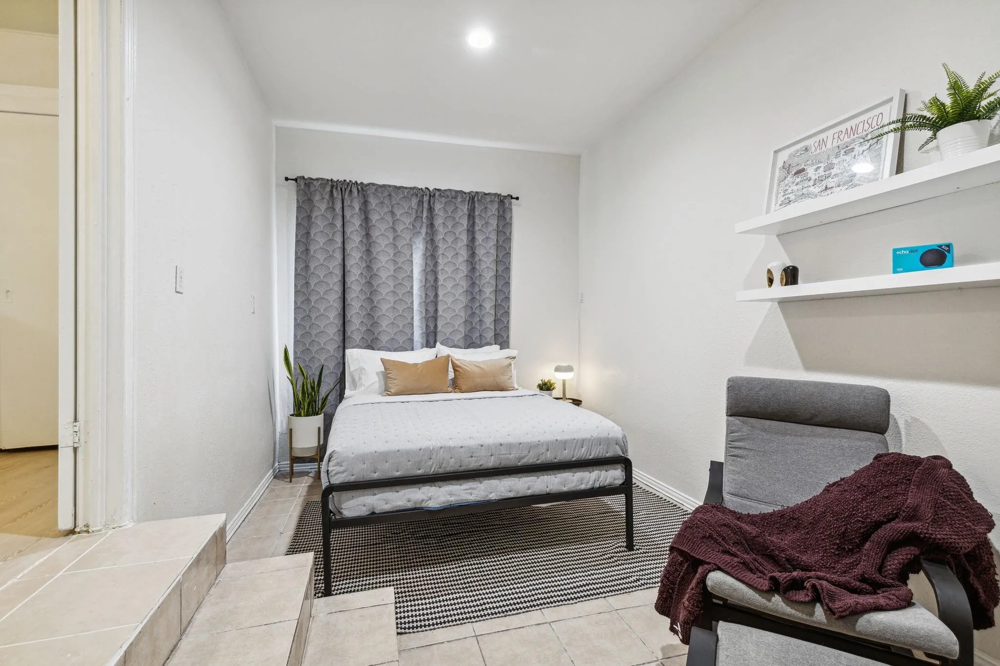 Wall-mounted floating shelves, recessed lighting, and tile flooring