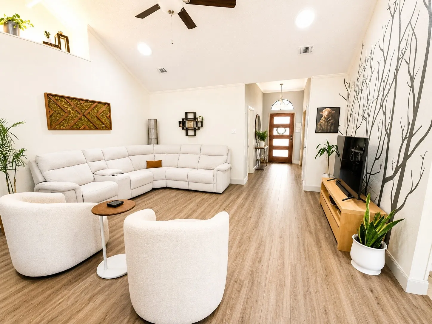 Vaulted ceiling with recessed lighting, wood-finish flooring, wood-paneled entry door with frosted glass inserts, and a built-in ceiling fan