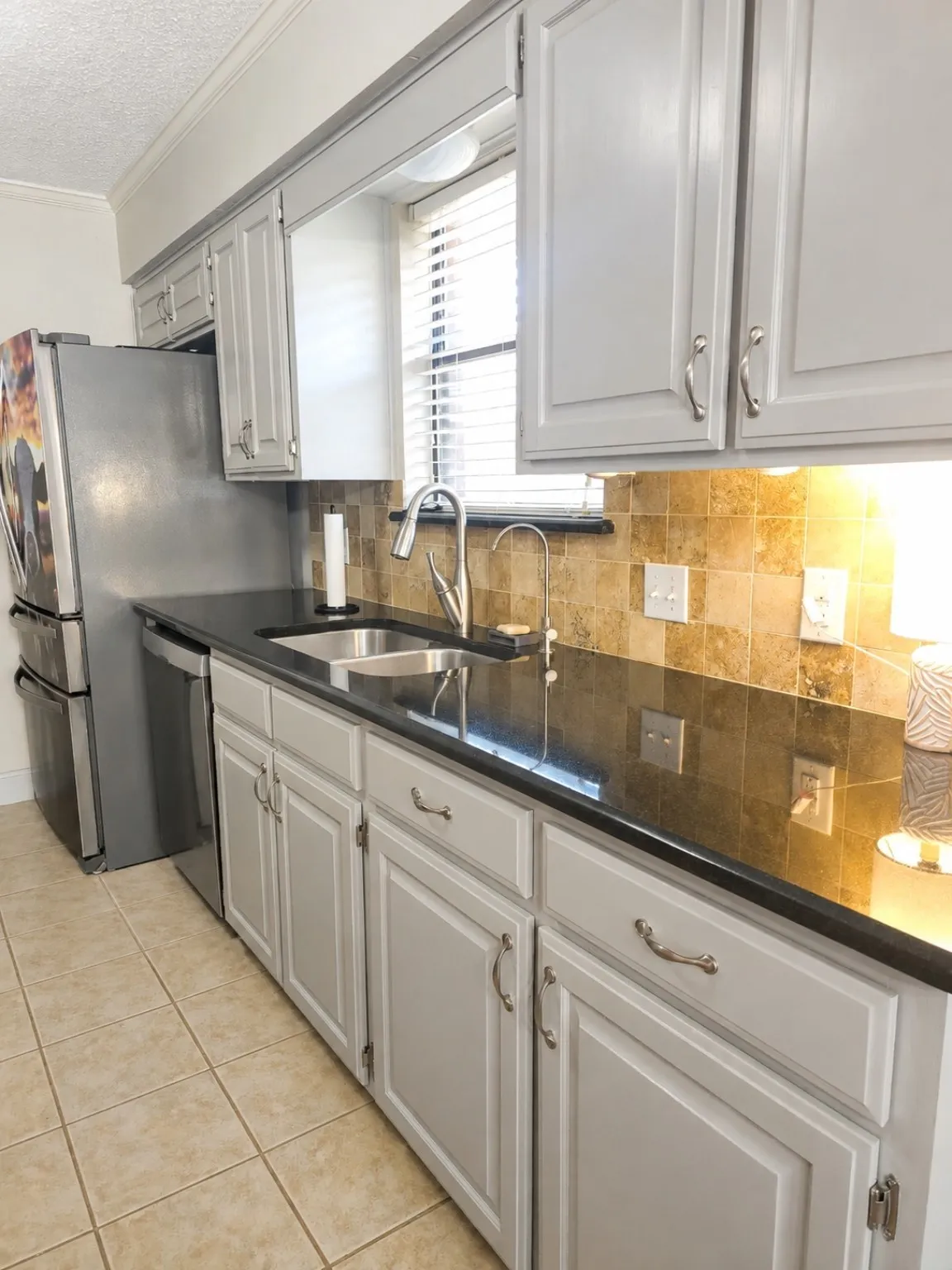 Neutral-toned tiled flooring complemented by light-toned cabinetry