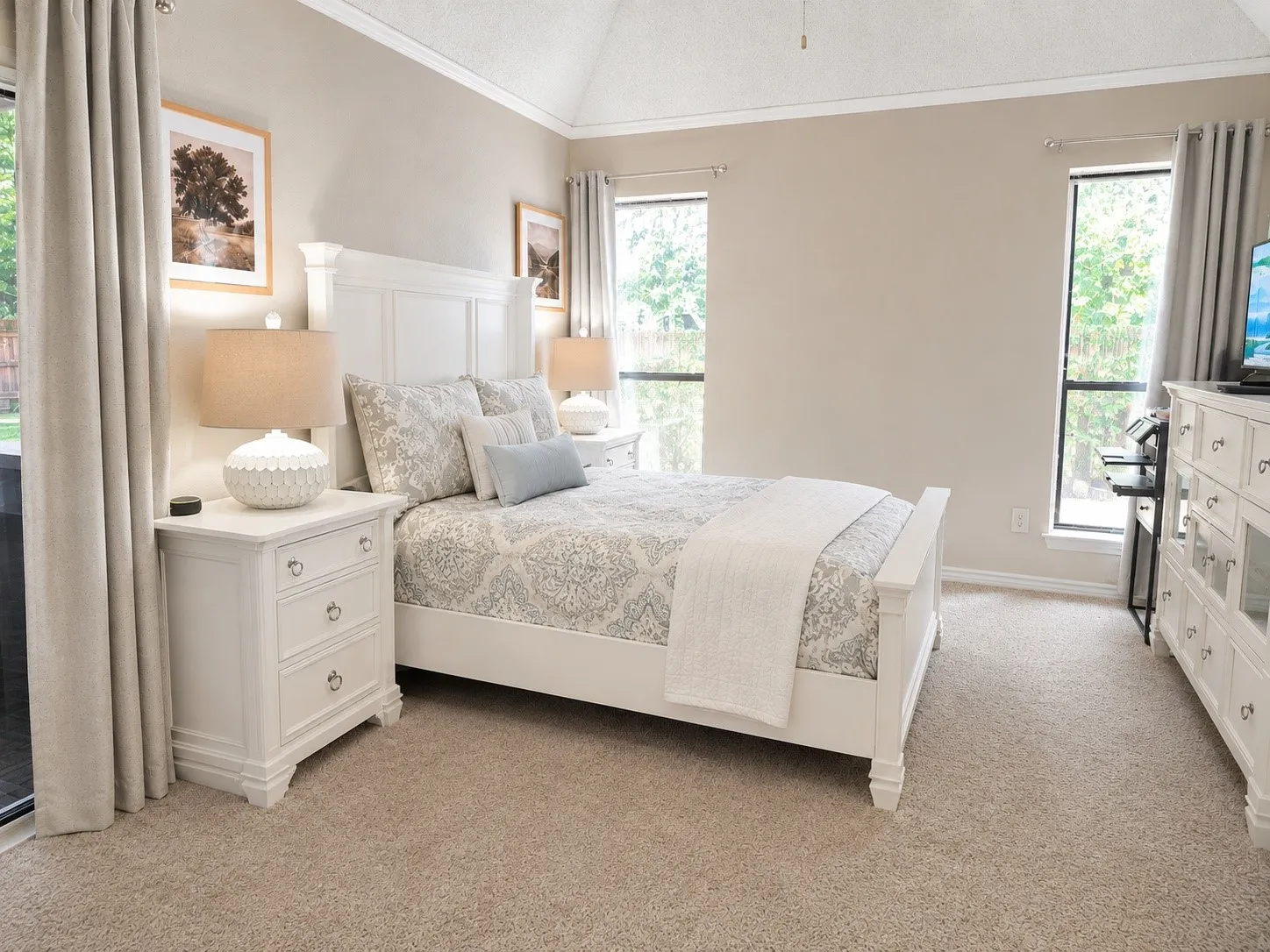 Vaulted ceiling, plush carpet, and dual windows with natural light