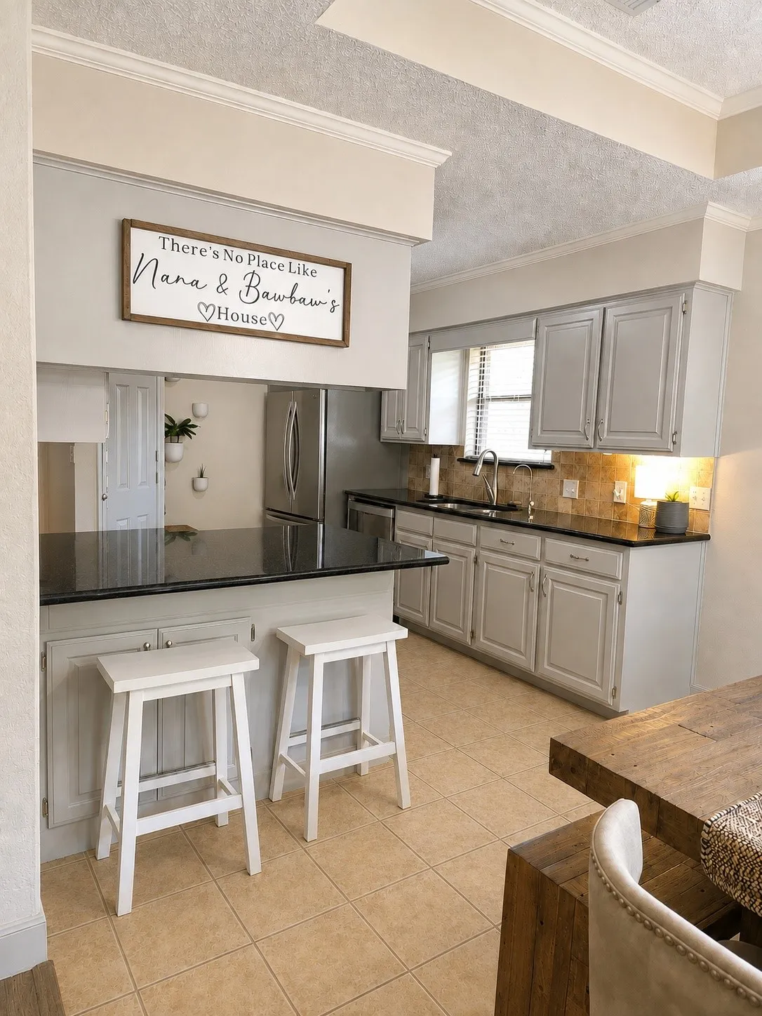 Kitchen featuring light gray cabinetry, dark solid surface countertops, a tiled backsplash, and stainless steel appliances