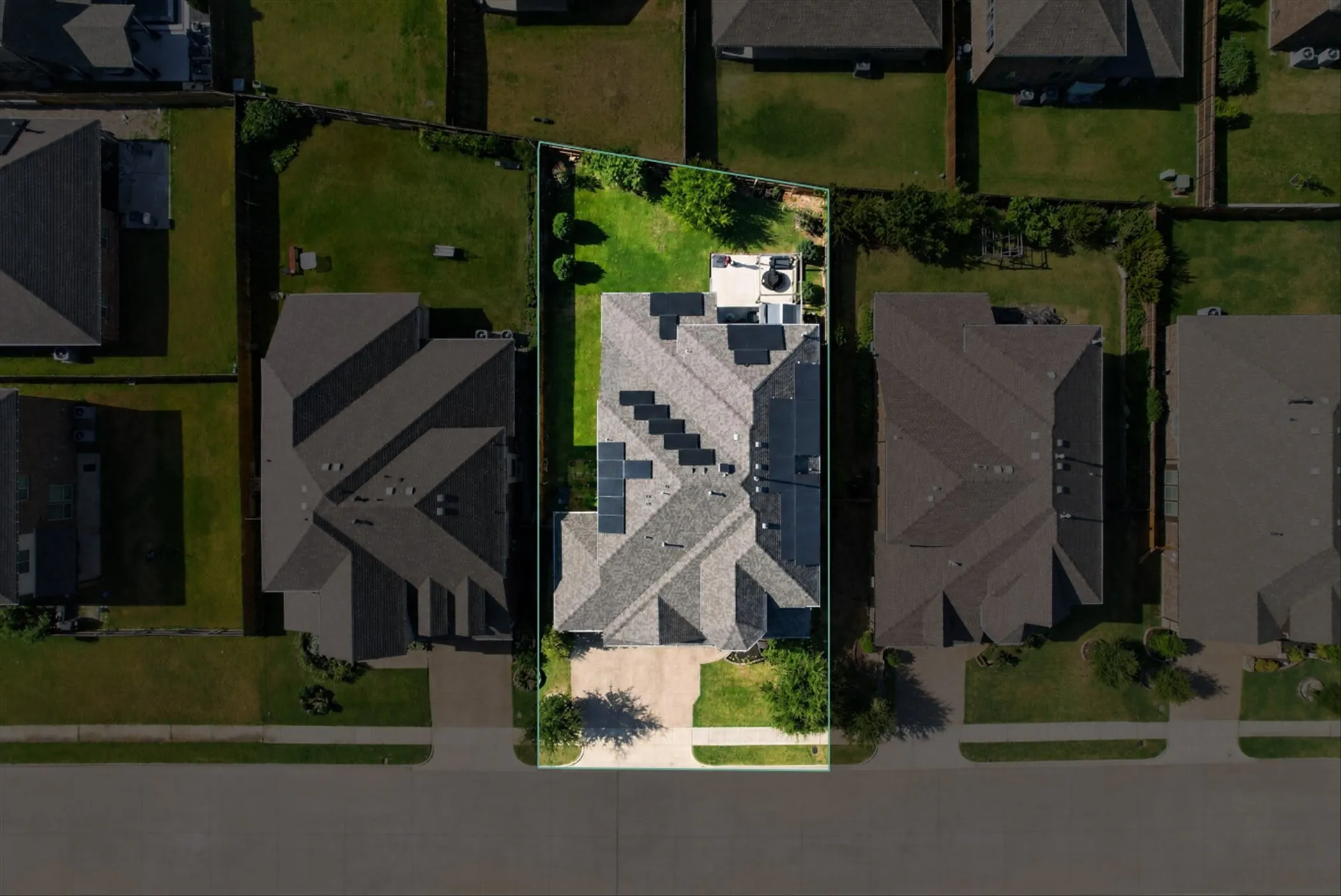 Expansive lot featuring a large rear yard, mature trees, and a concrete patio