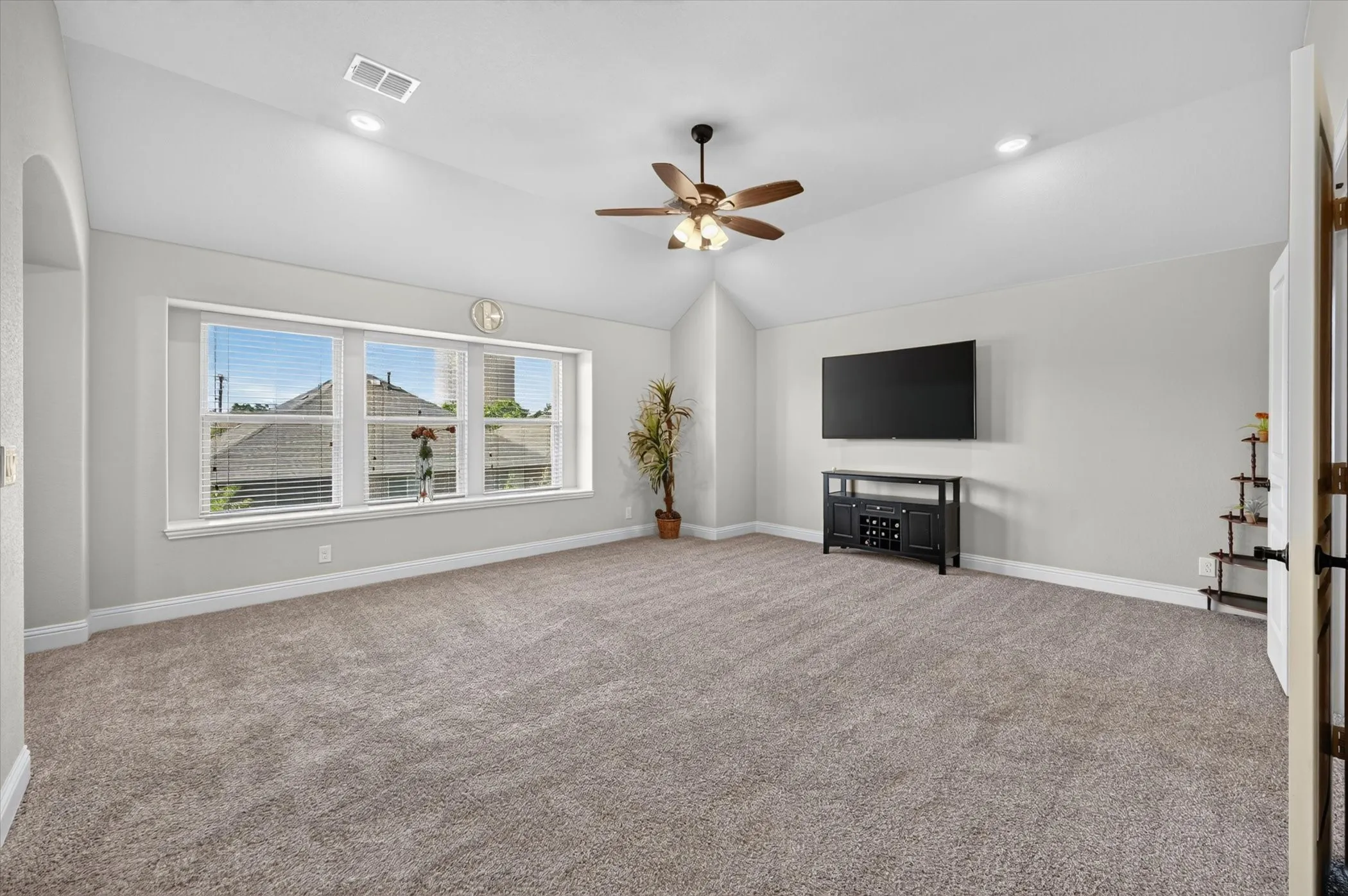 Vaulted ceiling with a ceiling fan, recessed lighting, and large windows with blinds