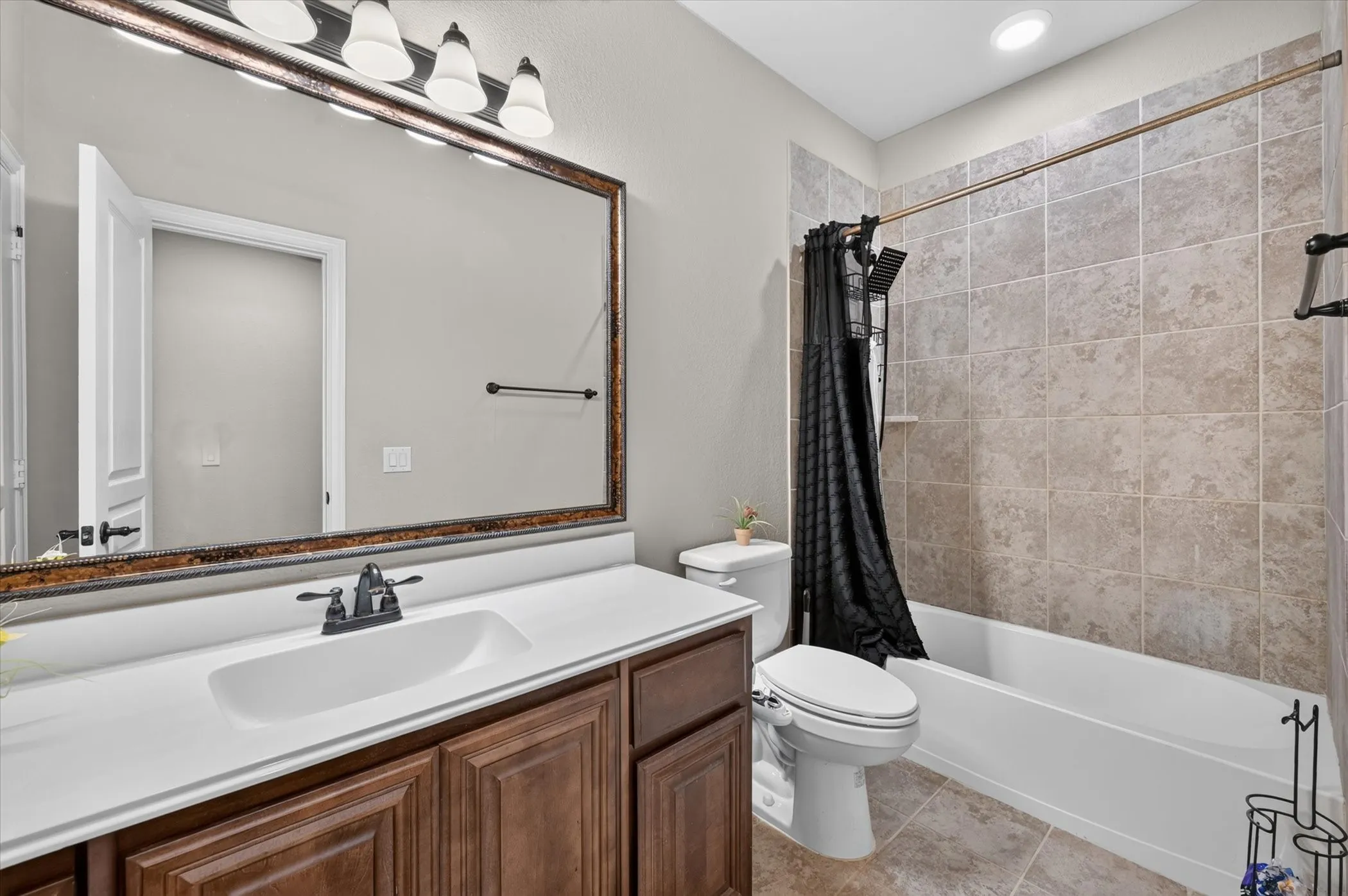 Bathroom 3 Wood-finish vanity with an integrated sink and matte black faucet