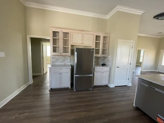 Wood-finish flooring throughout, complemented by crown molding and light-toned walls