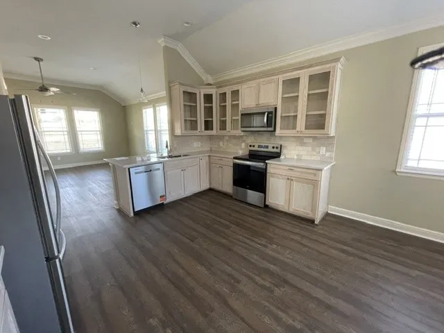 Kitchen featuring light-finish cabinetry, stainless steel appliances, and a tiled backsplash