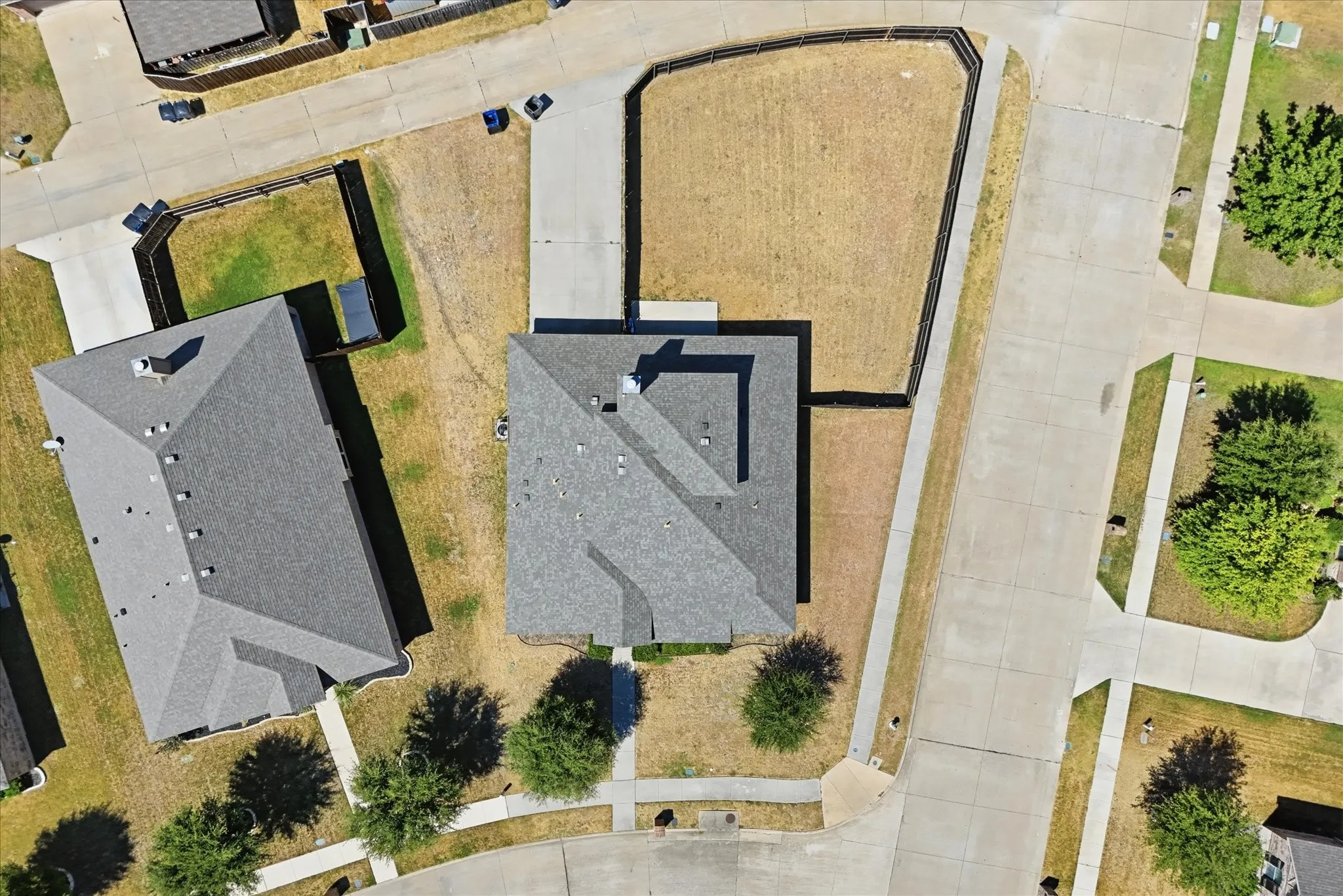 Pitched roofline residence with a detached garage structure and paved driveway