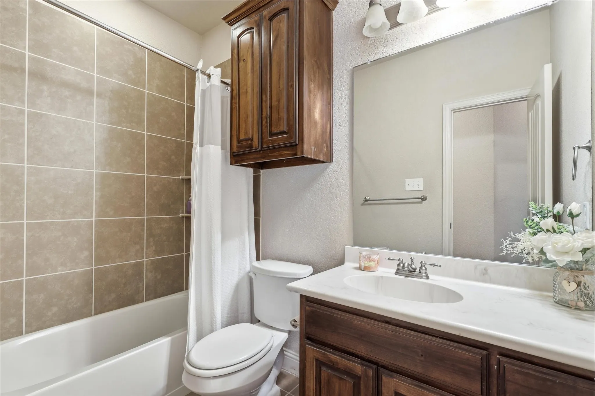 Bathroom featuring a vanity with dark wood-finish cabinetry, a white countertop, and an undermount sink