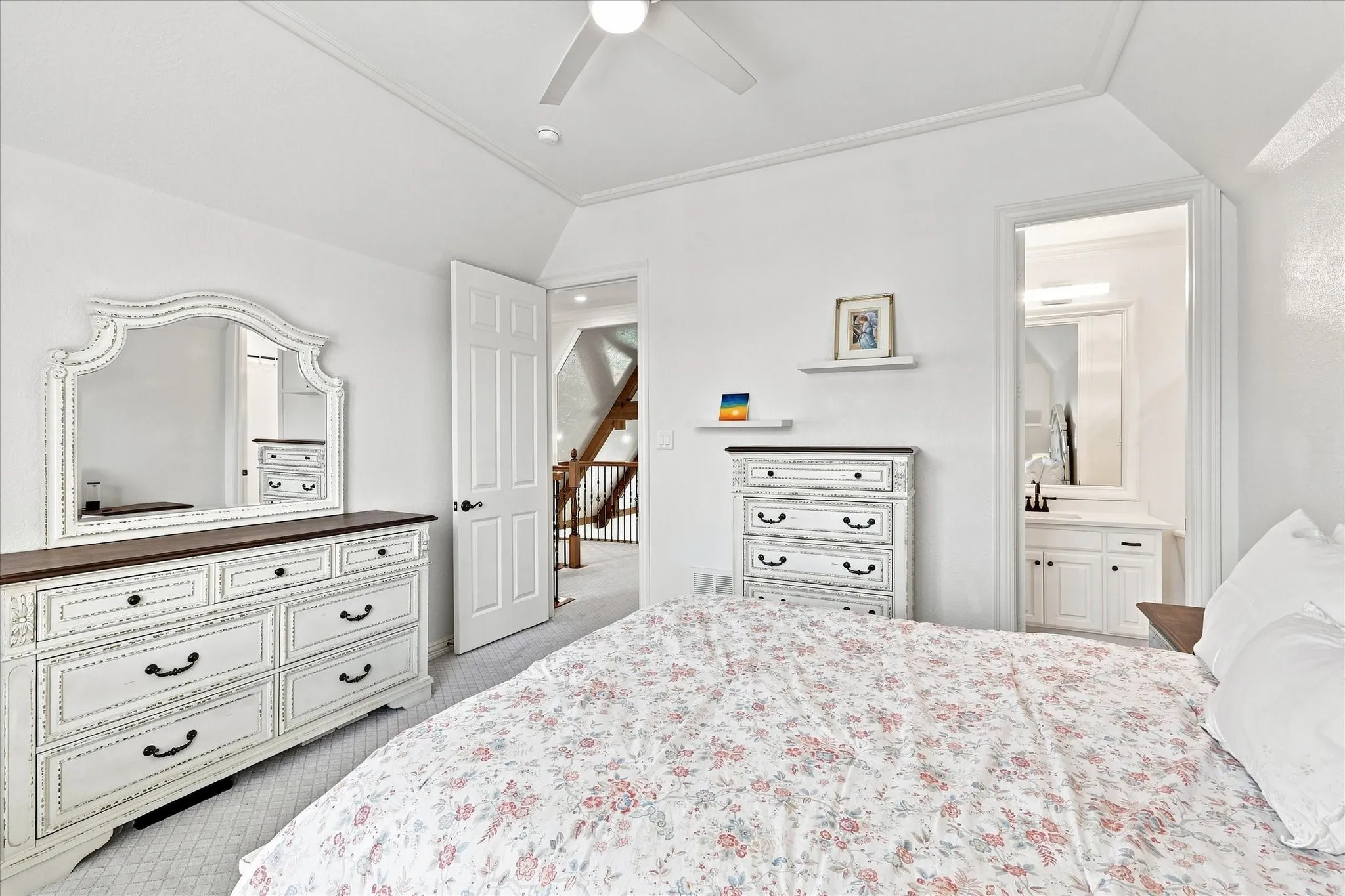 White painted walls and vaulted ceiling featuring a ceiling fan