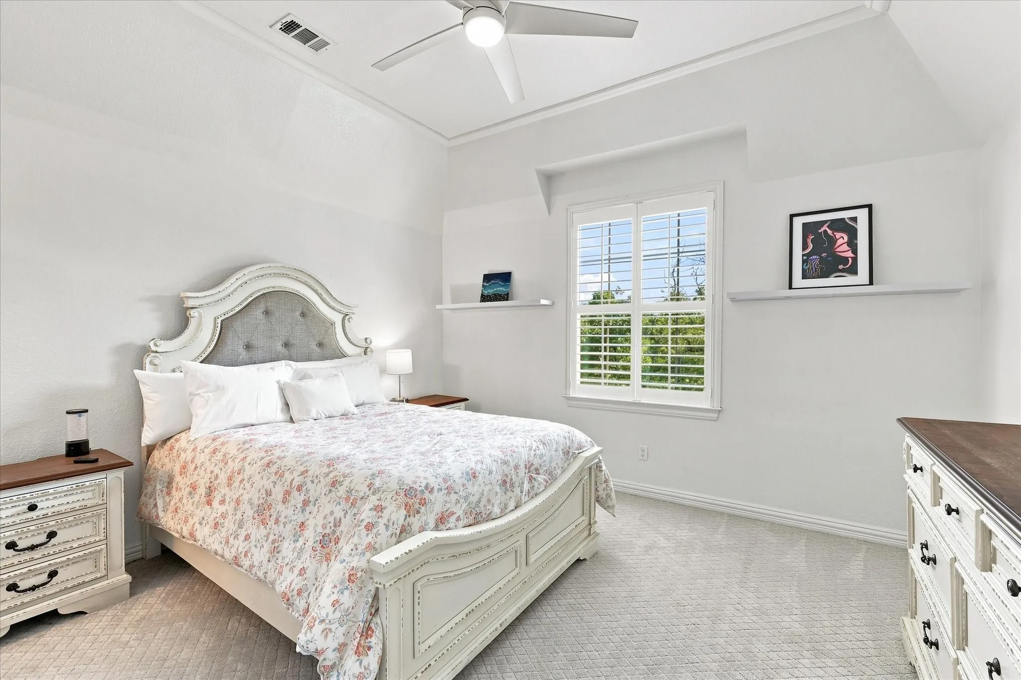 Vaulted ceiling with a ceiling fan, window with plantation shutters, wall-mounted shelving, and carpet flooring
