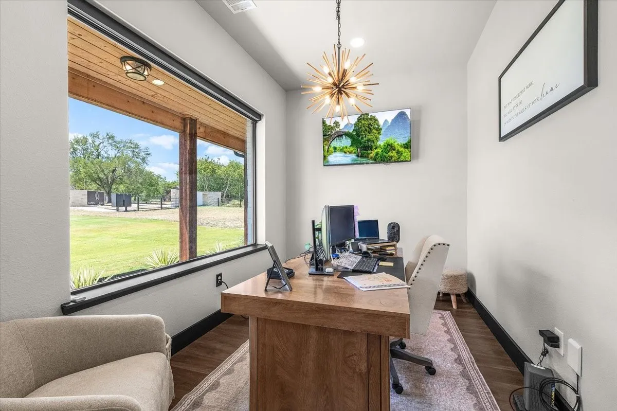 Expansive window with black trim, wood-finish flooring, and a contemporary sputnik chandelier