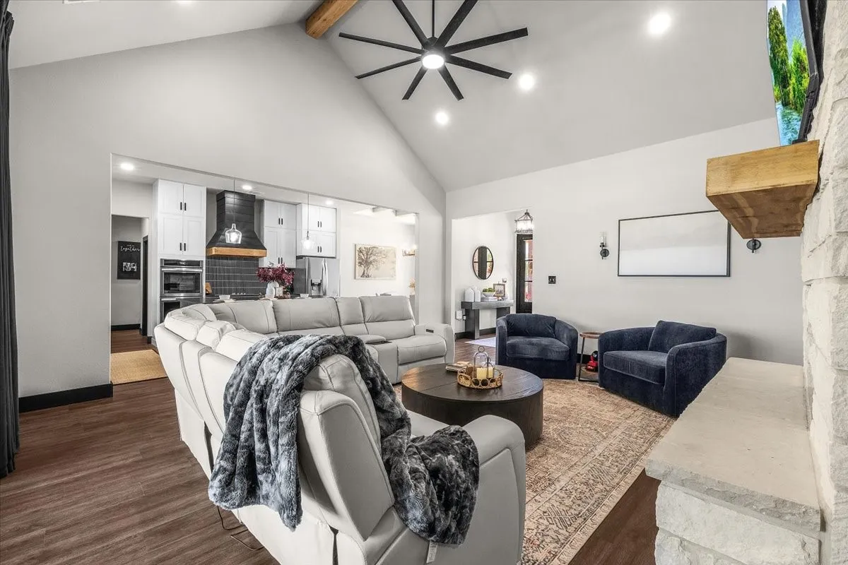 Vaulted ceiling with exposed wood beam, recessed lighting, and a modern ceiling fan