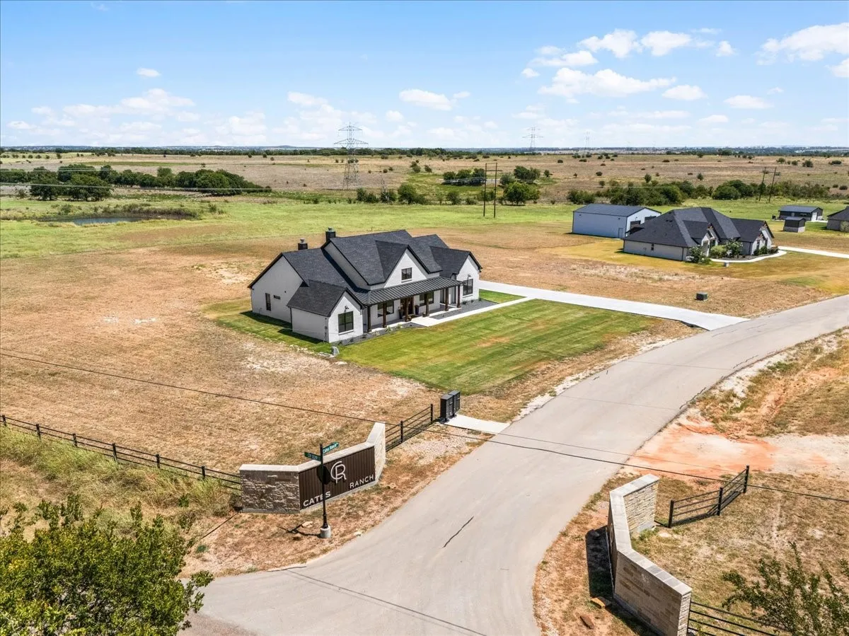 Modern farmhouse-style home with a dark shingle roof, white siding, and a covered porch