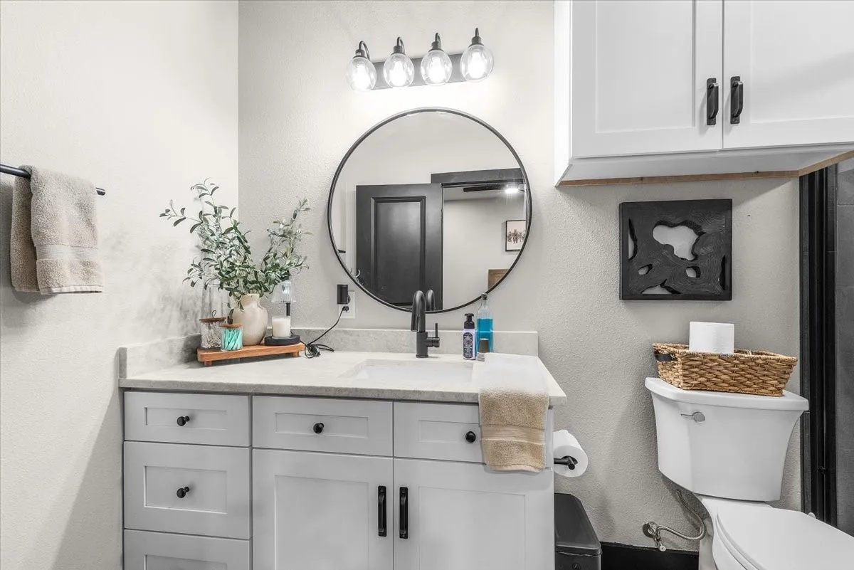 White vanity with black hardware, integrated sink, and light-colored countertop