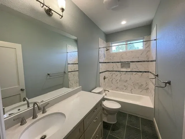 Bathroom featuring a vanity with an integrated sink, a quartz-finish countertop, and brushed nickel fixtures