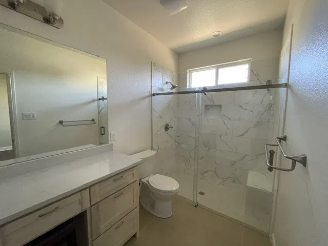 Vanity with a light-toned countertop, large mirror, and built-in cabinetry