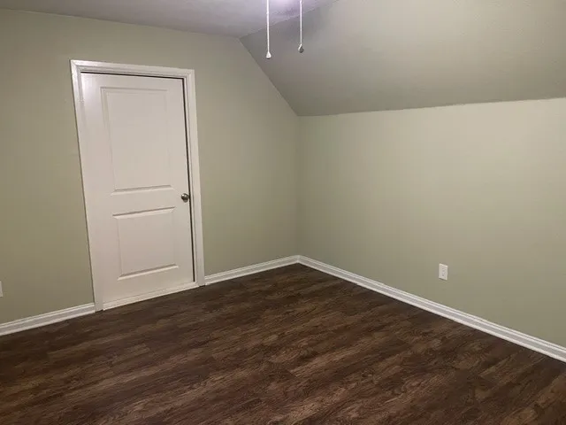 Wood-finish flooring, light-toned walls, and a white paneled door