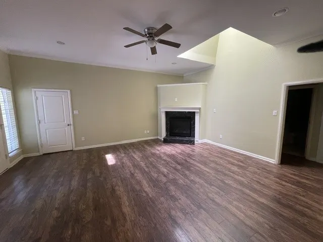  integrated skylight, wood-finish flooring, and a fireplace with a dark stone surround