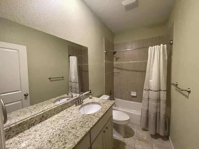Dual vanity with an expansive granite countertop, undermount sinks, and brushed nickel fixtures