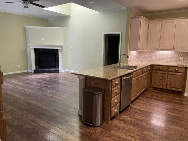Kitchen island with integrated sink, stainless steel dishwasher, and granite countertop