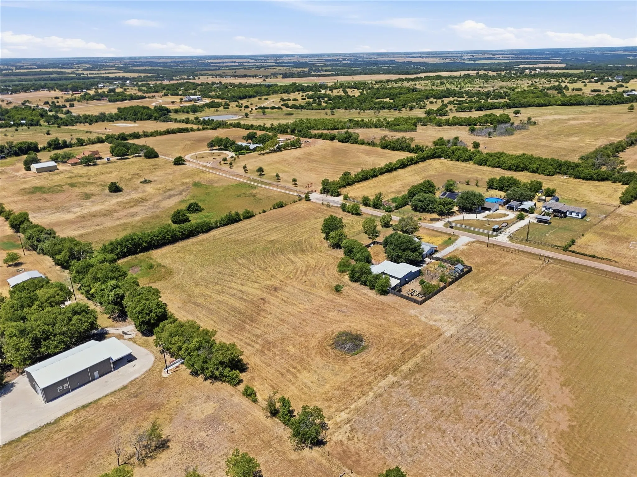 Expansive acreage with multiple structures, including a primary residence, detached outbuilding, and a separate structure with a pool
