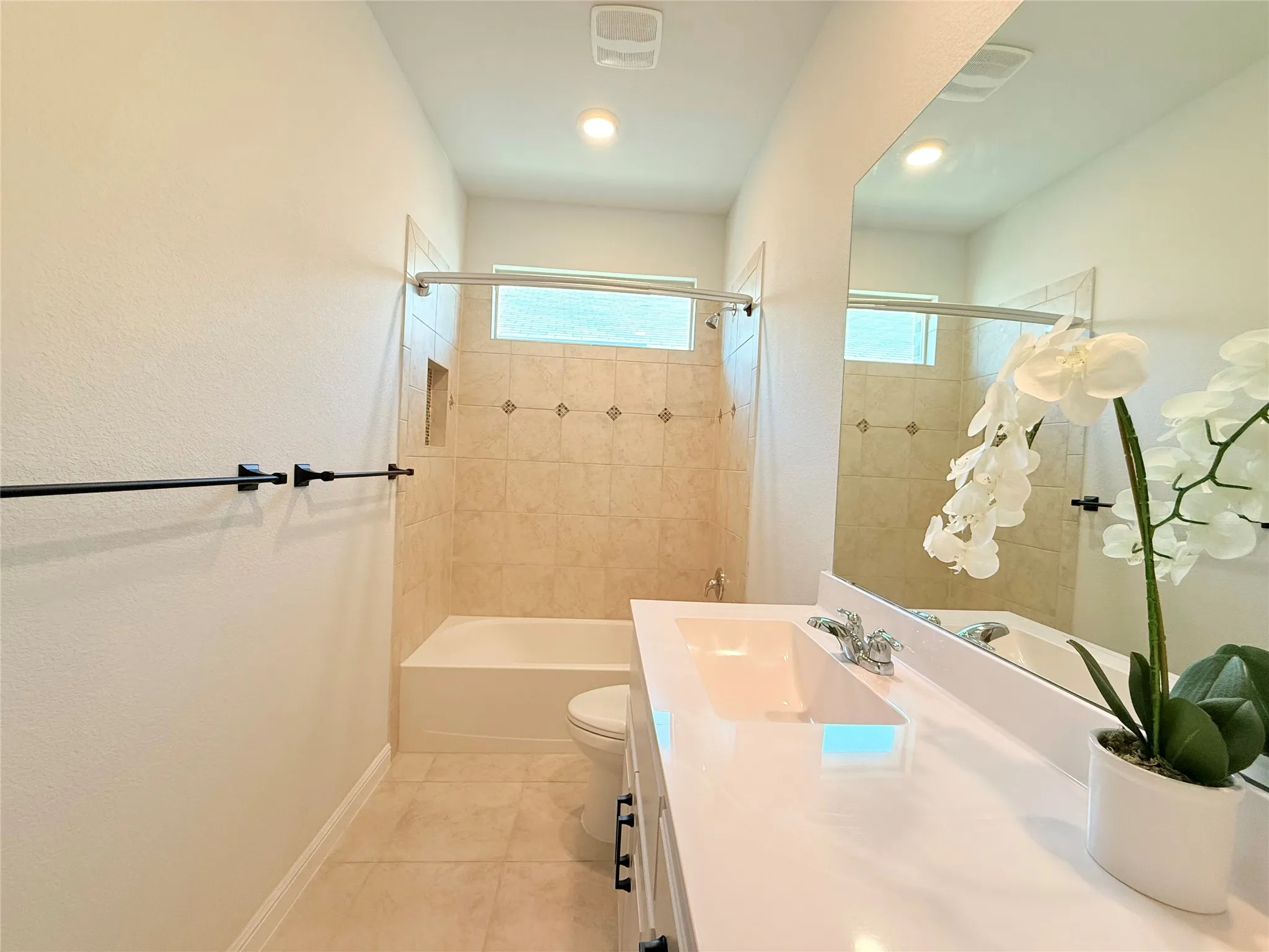 Built-in bathtub with tiled surround featuring decorative accents
