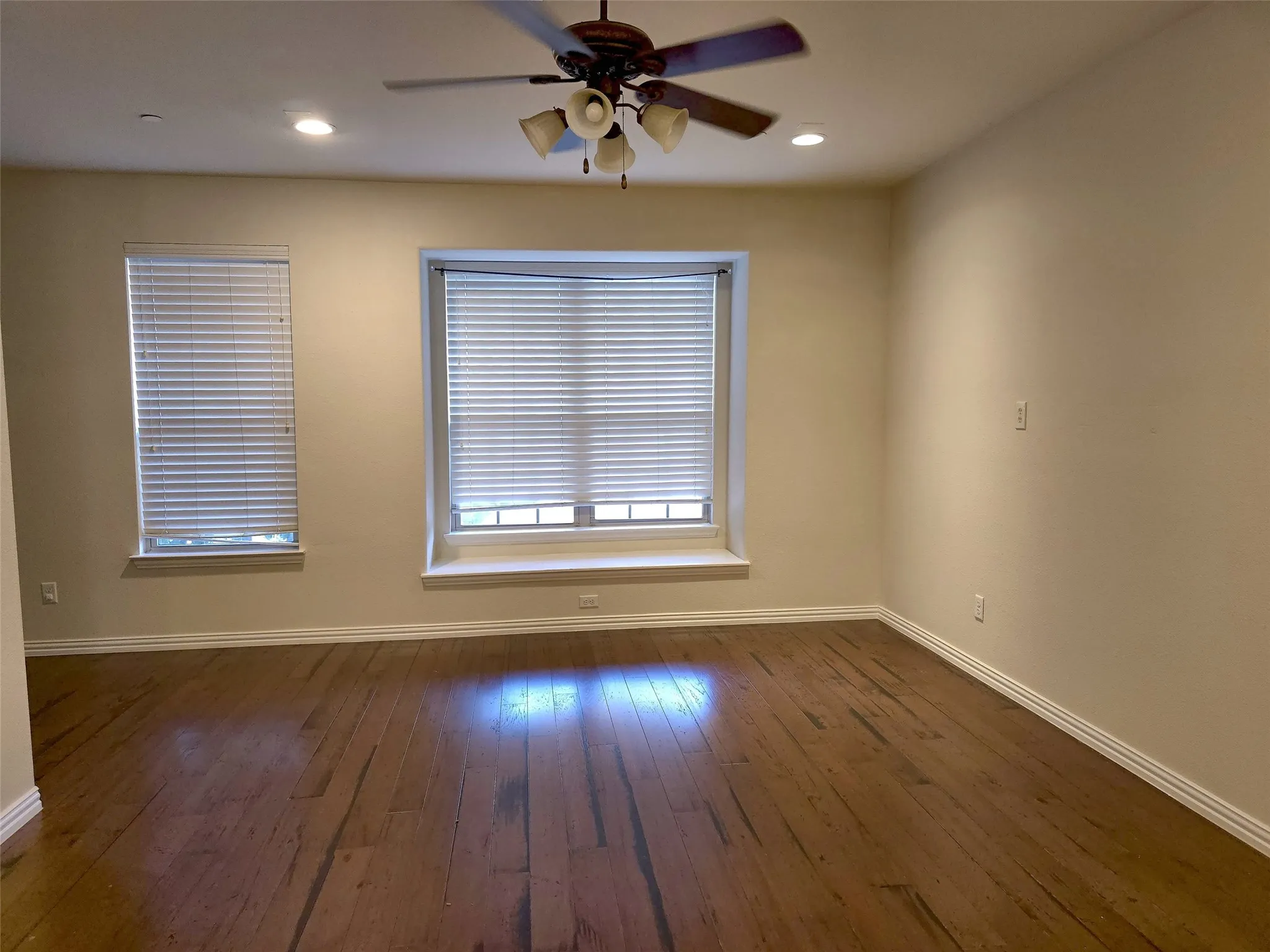 Wood-finish flooring, recessed lighting, and a ceiling fan with integrated light fixture