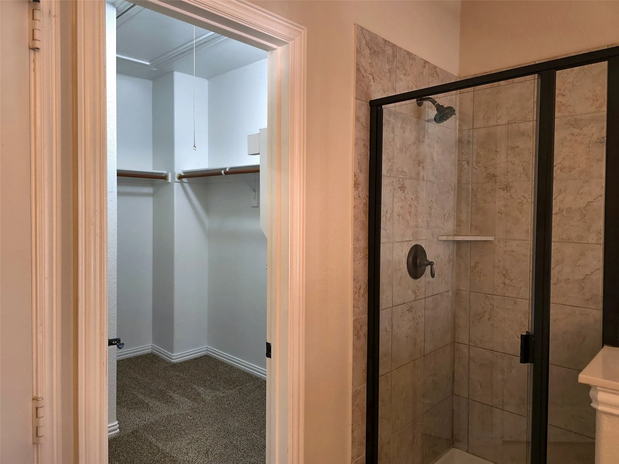 Walk-in shower with clear glass enclosure and tile surround