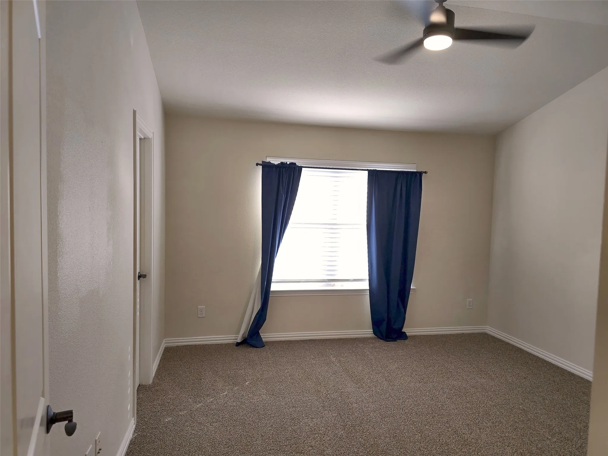 Carpeted flooring, recessed window, ceiling fan with integrated lighting, and neutral wall tones