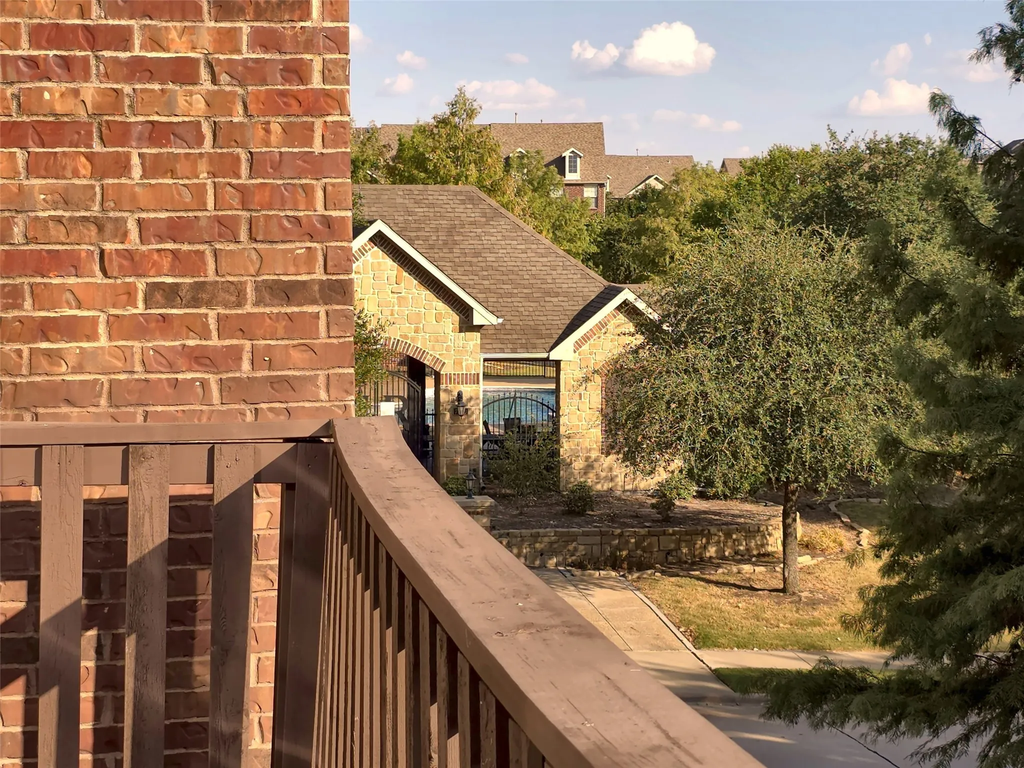 Exterior brick wall with a wooden railing