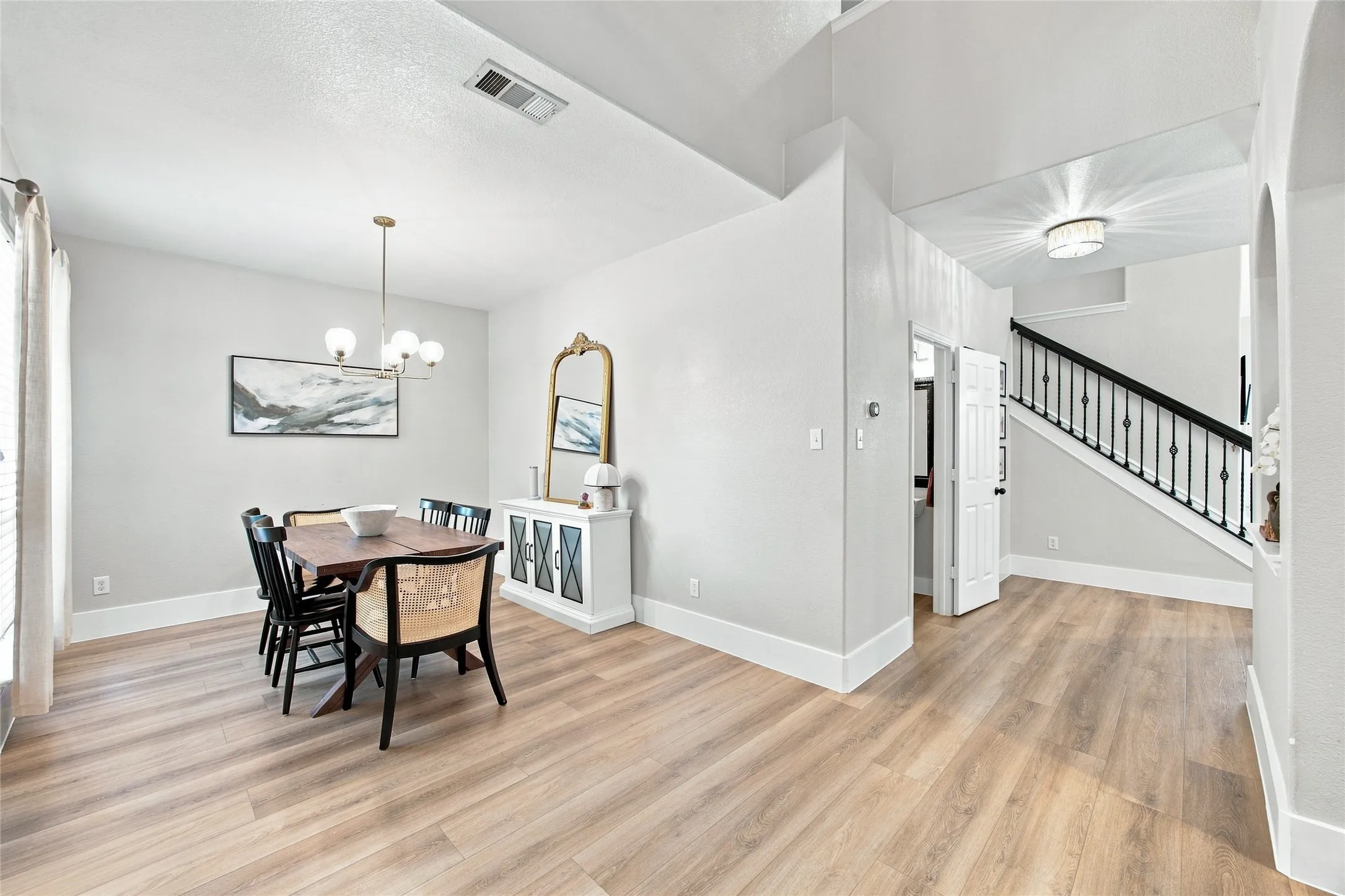 As you enter the home you will see the beautiful wood-finish flooring throughout, bright walls, contemporary chandelier, high ceilings, spacious dining room, an open staircase with dark balusters