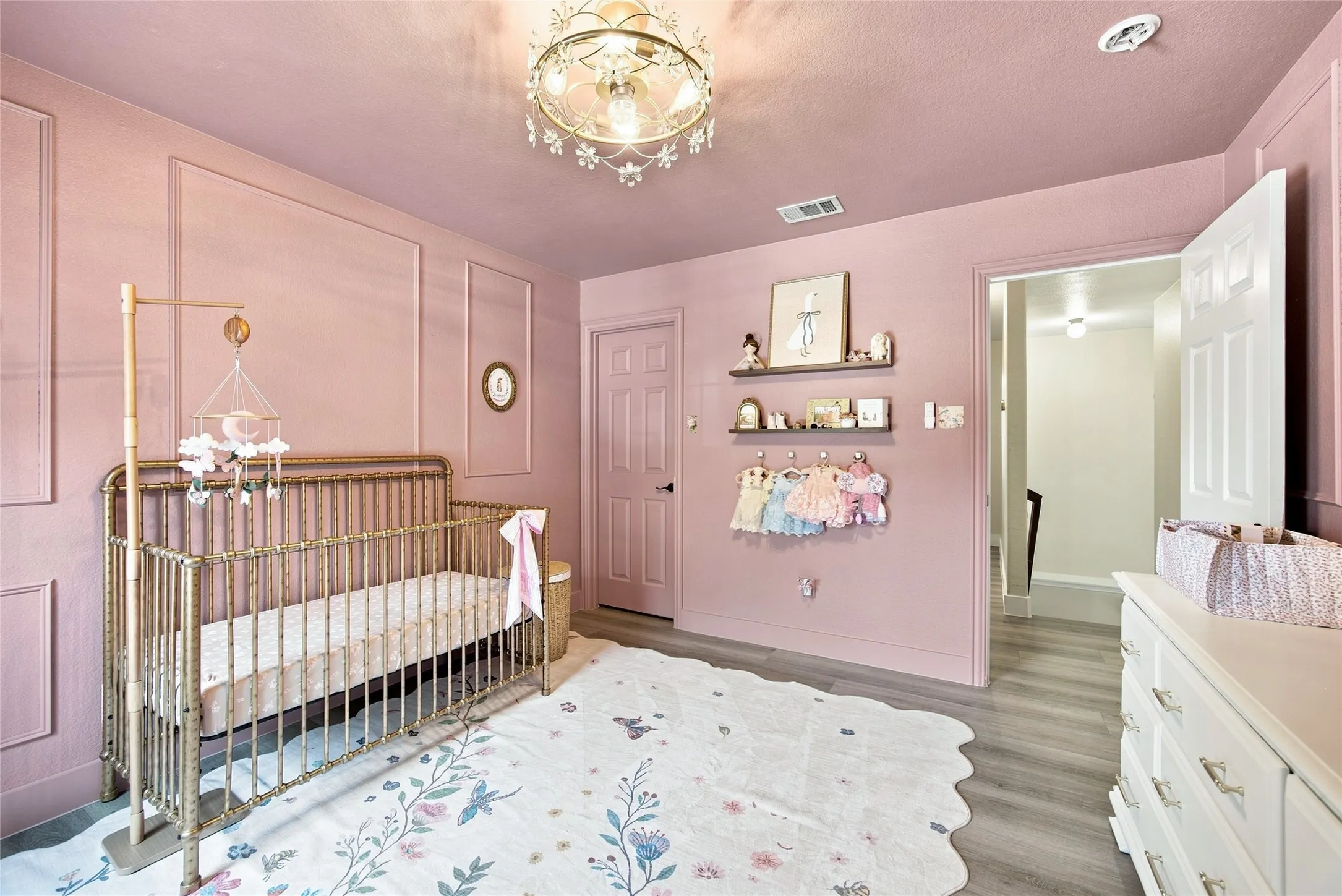 Adorable nursery with custom picture frame molding on the walls bringing warmth to the room along with great open of space for your little ones and a walk in coset with plenty of storage.