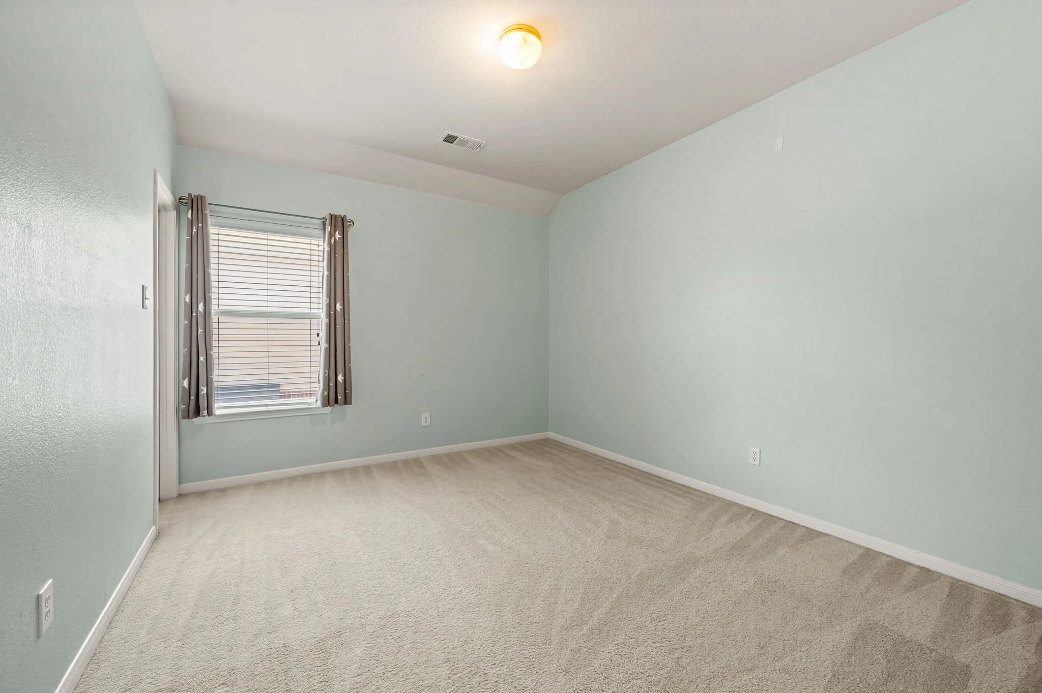 Wall-to-wall carpeting with light-toned walls and a window with blinds