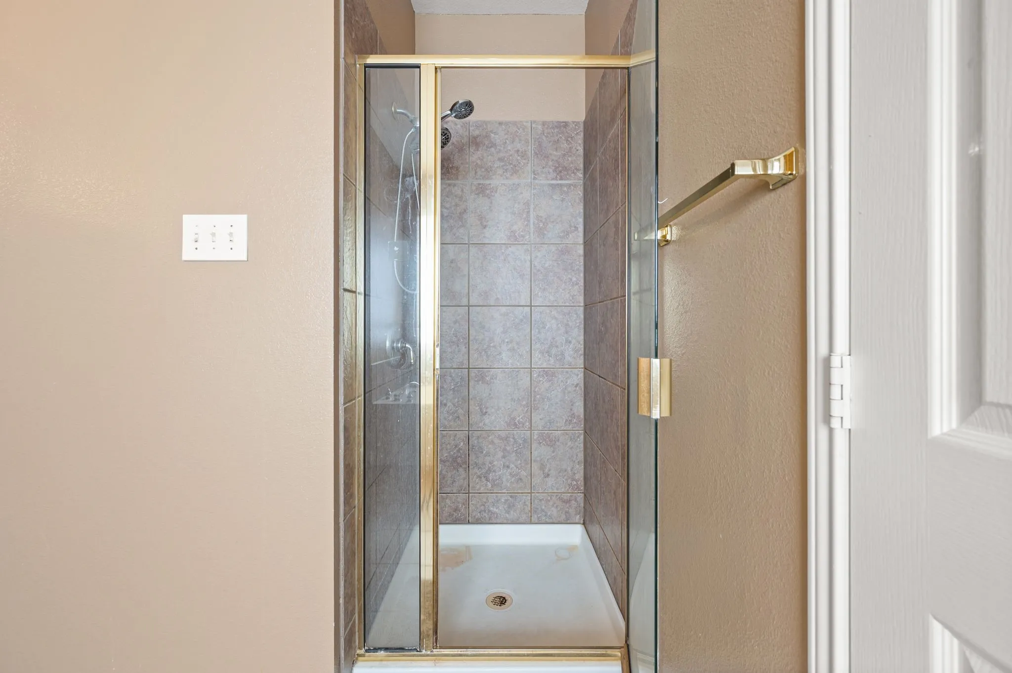 Shower enclosure featuring a framed glass door, tiled walls, and a built-in showerhead