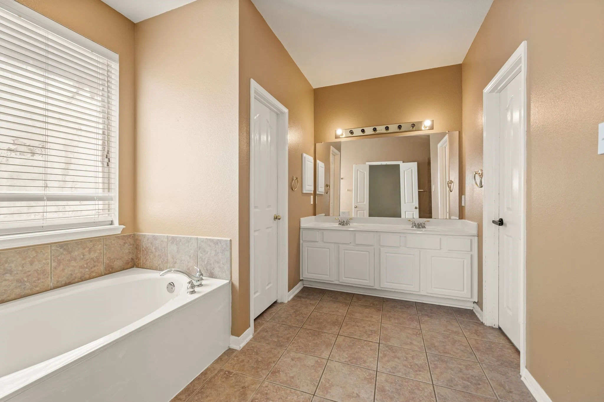 Dual vanity with integrated sinks, framed mirror, and overhead light fixture