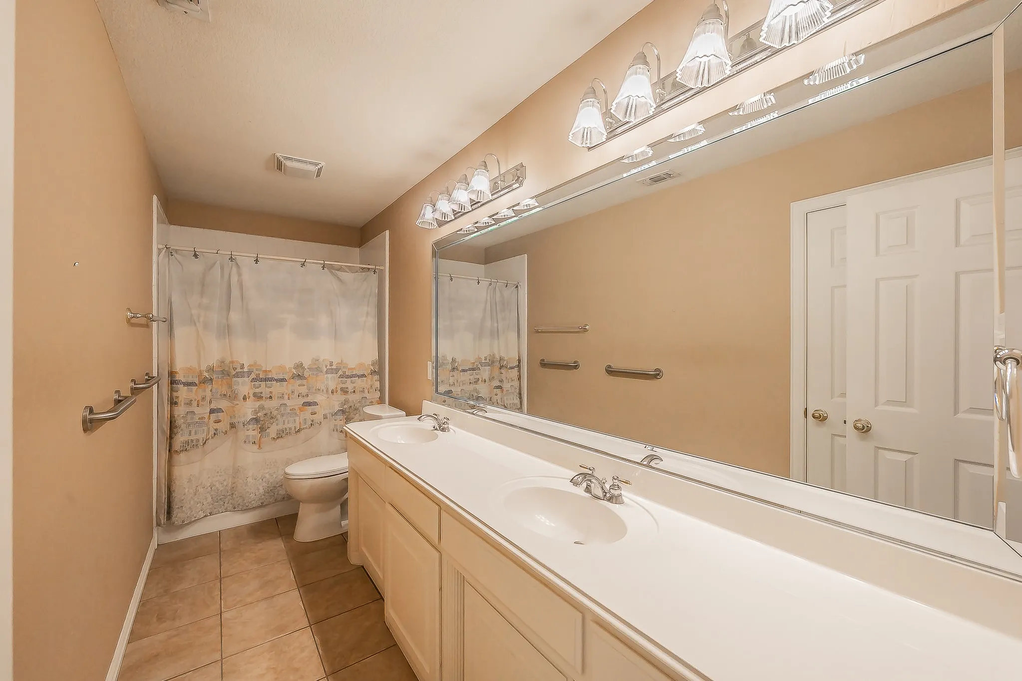 Double vanity with integrated sinks, full-width mirror, and a multi-light fixture