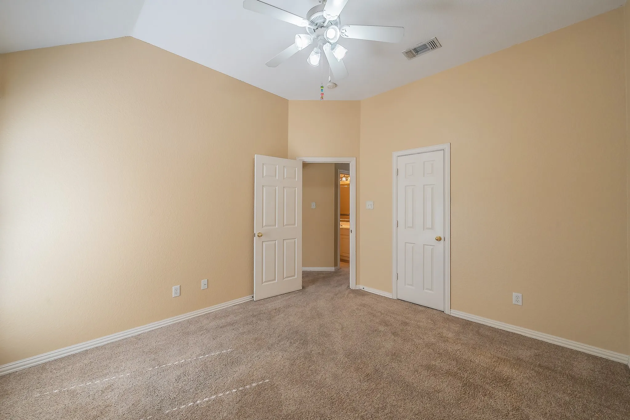 Vaulted ceiling, ceiling fan, carpet flooring, baseboards, paneled doors