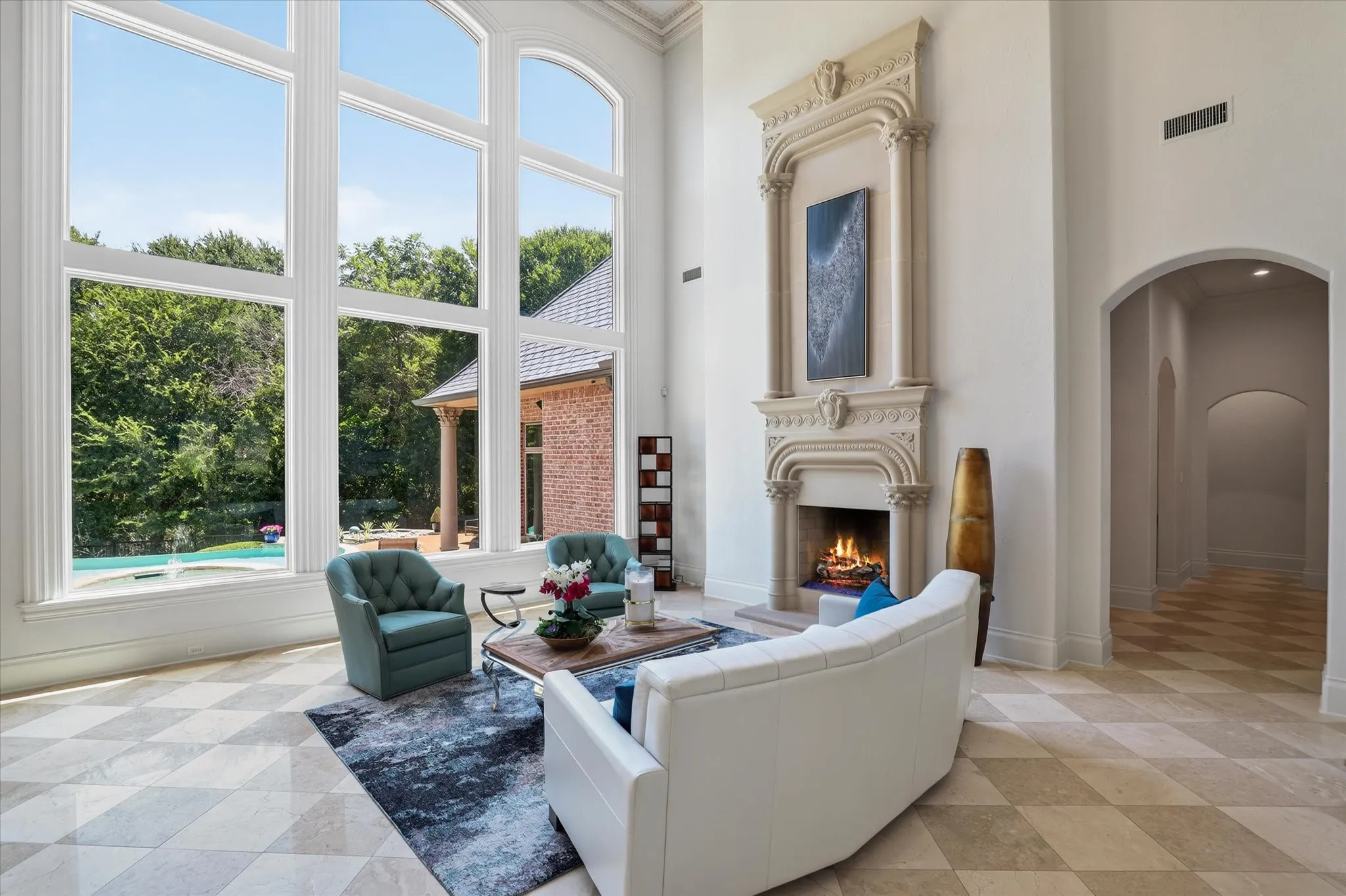 Grand Living area offers soaring ceilings, floor to ceiling windows and a beautiful custom fireplace.