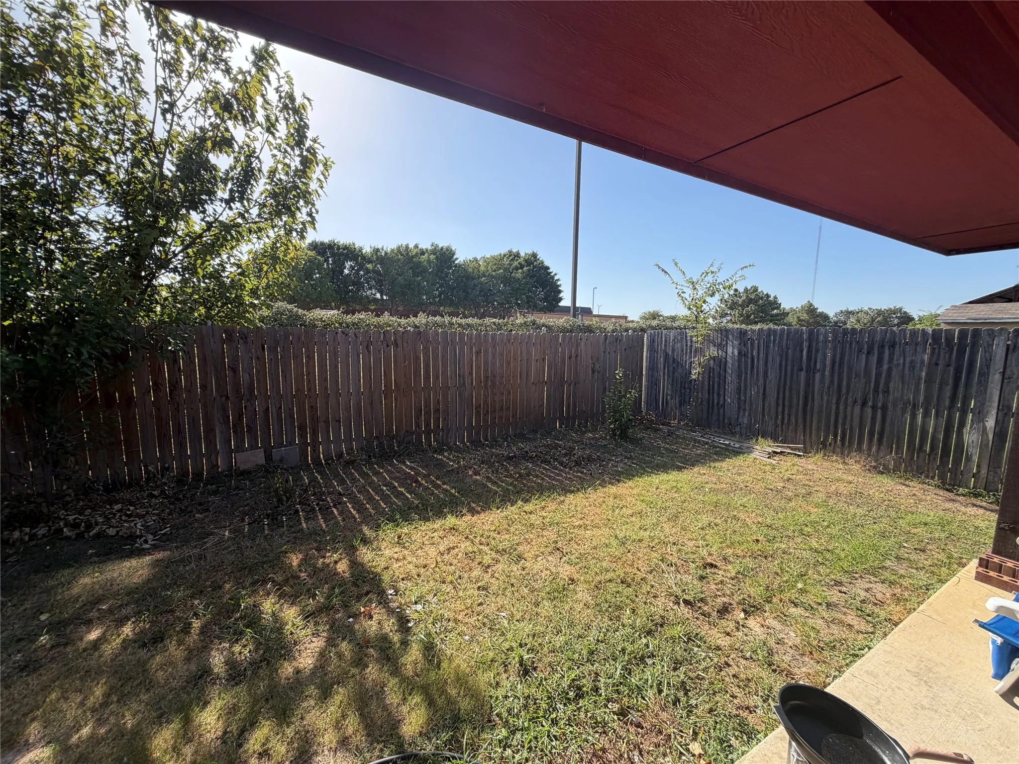 Private fenced yard with an integrated covered patio area and mature perimeter trees