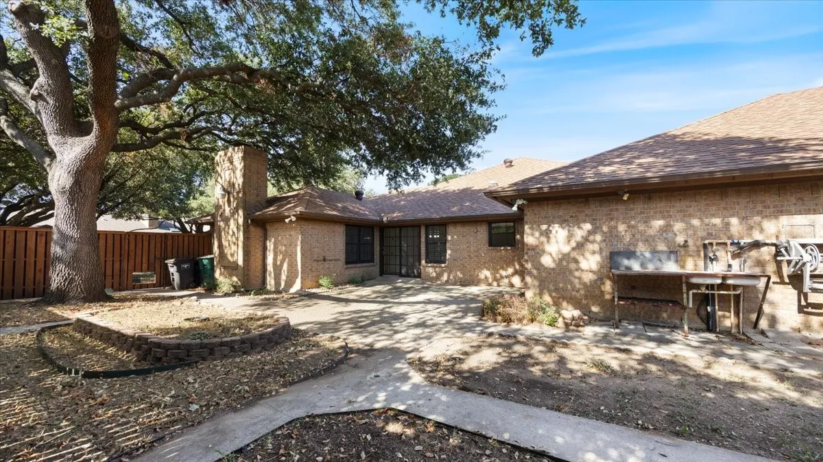 Back of house with large patio and raised beds.